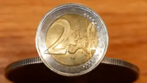 Moneta da 2 euro in primo piano su sfondo in legno