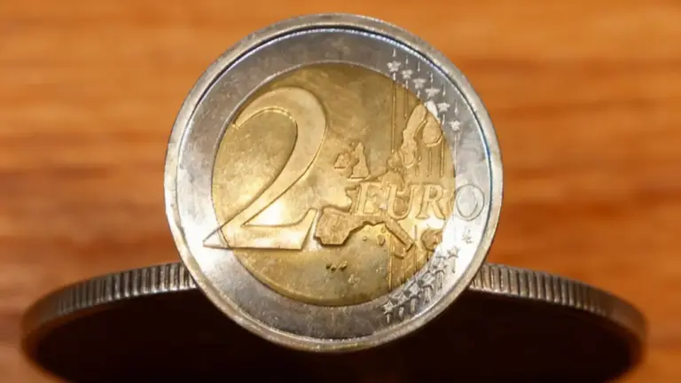 Moneta da 2 euro in primo piano su sfondo in legno