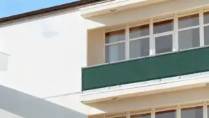 Pannello frangivista verde installato su un balcone di un edificio residenziale